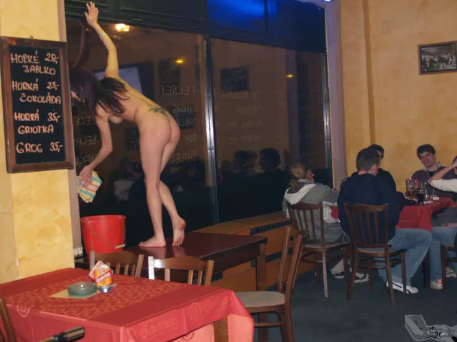 Agi cleans the window. Naked. In the bar.