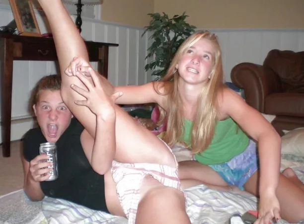 Cutie drinks a beer while her friend stretches her out