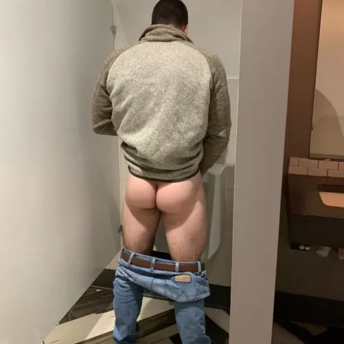 I always pull down my pants at the urinal. No one cares.