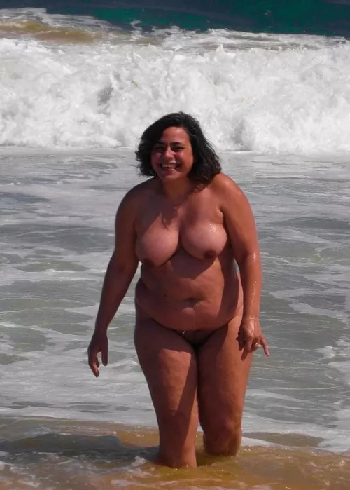 Lovely plump nudist frolicing in the waves