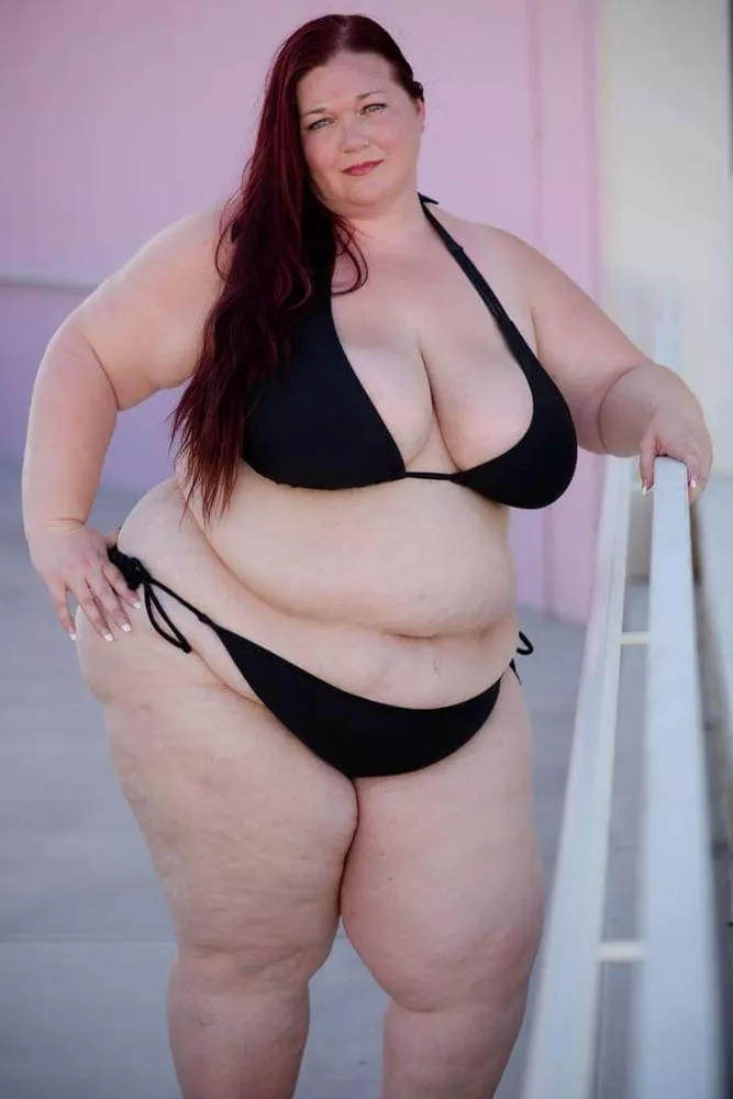 Plump and pale redhead in a black bikini