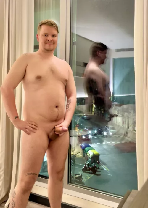 Night time, busy street, big window, lights on, happy exhibitionist