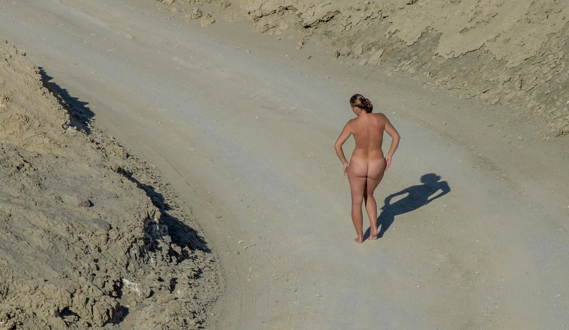 An adventurous naked stroll along the dirt road in Twenty Mule Team Canyon in Death Valley.