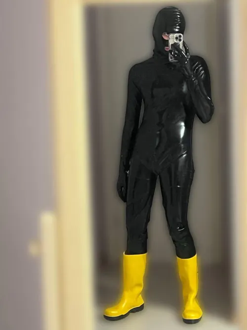 Black catsuit, hood, gloves, boots, very submissive