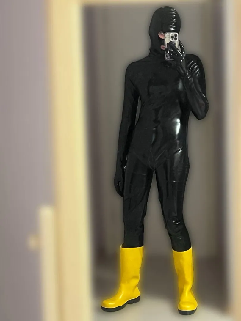 Black catsuit, hood, gloves, boots, very submissive