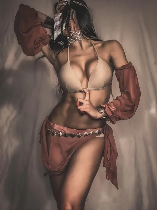 Chains and gems catch the light against warm skin