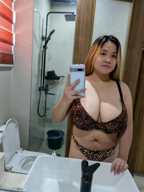 Mirror selfie glow catching the golden highlights in her hair and the depth of her cleavage