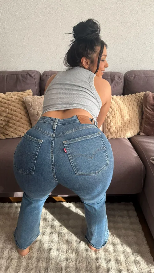 Tanned curves in tight denim igniting bold energy ruling the shore with fiery warmth