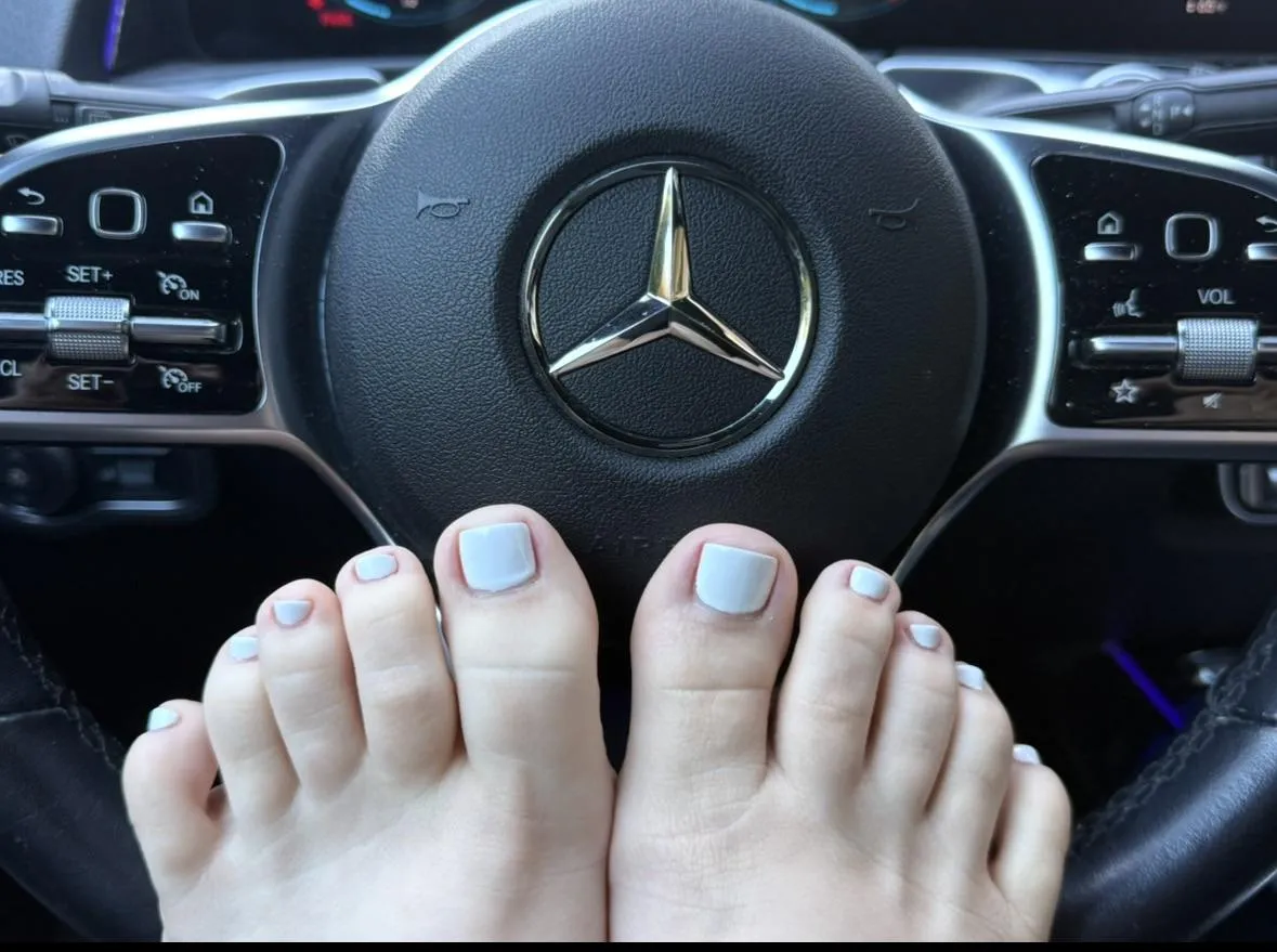 This milf showing off her white toes in her car