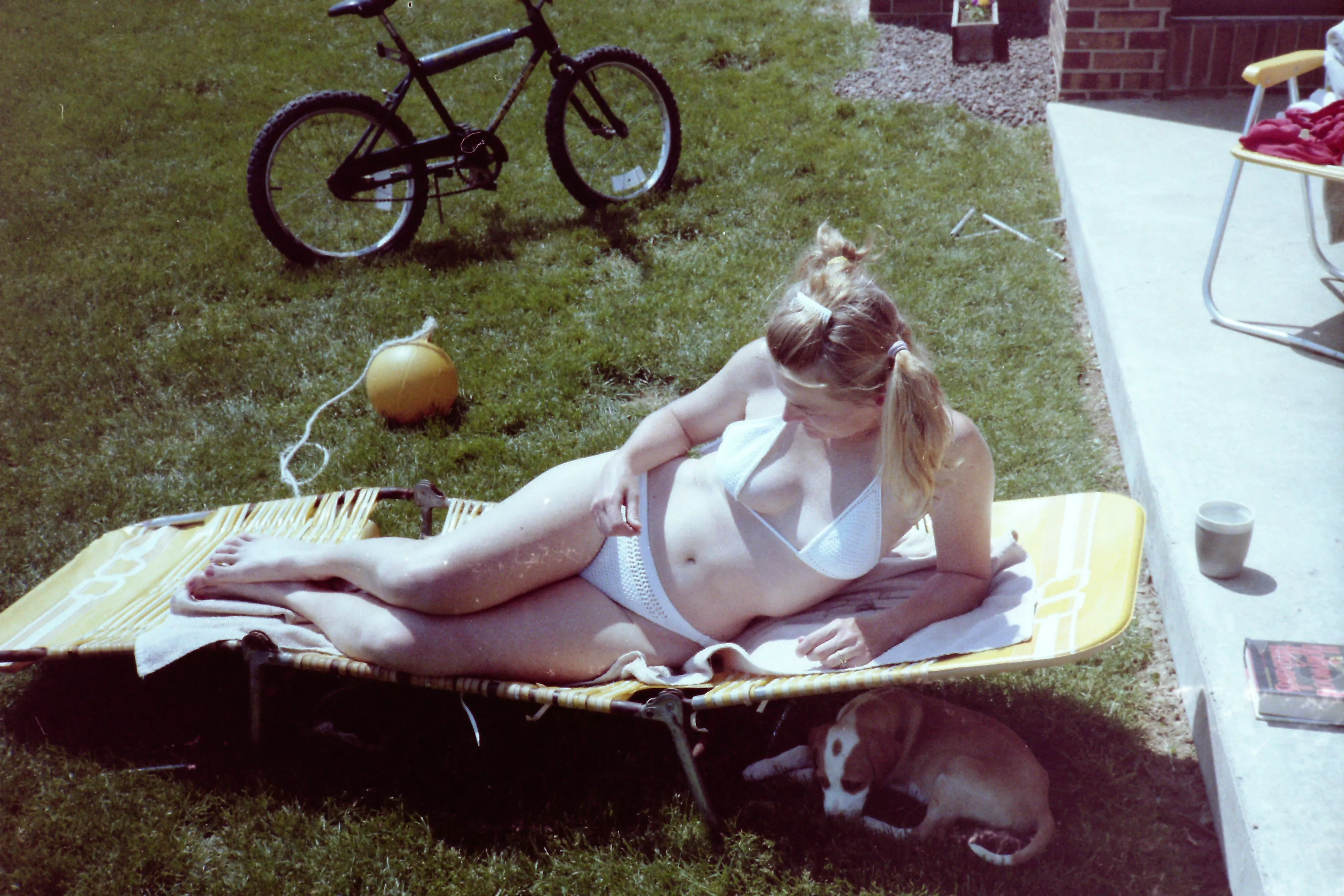 1980s mom sunning in her backyard....