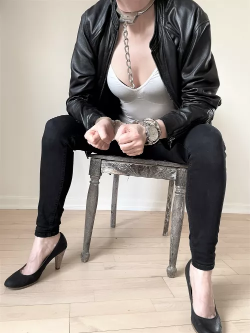 Neck-cuff with hinged cuffs, leather jacket, and heels