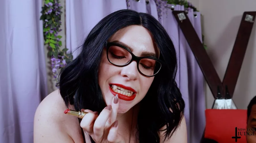 Vampire touching up her bright red lips