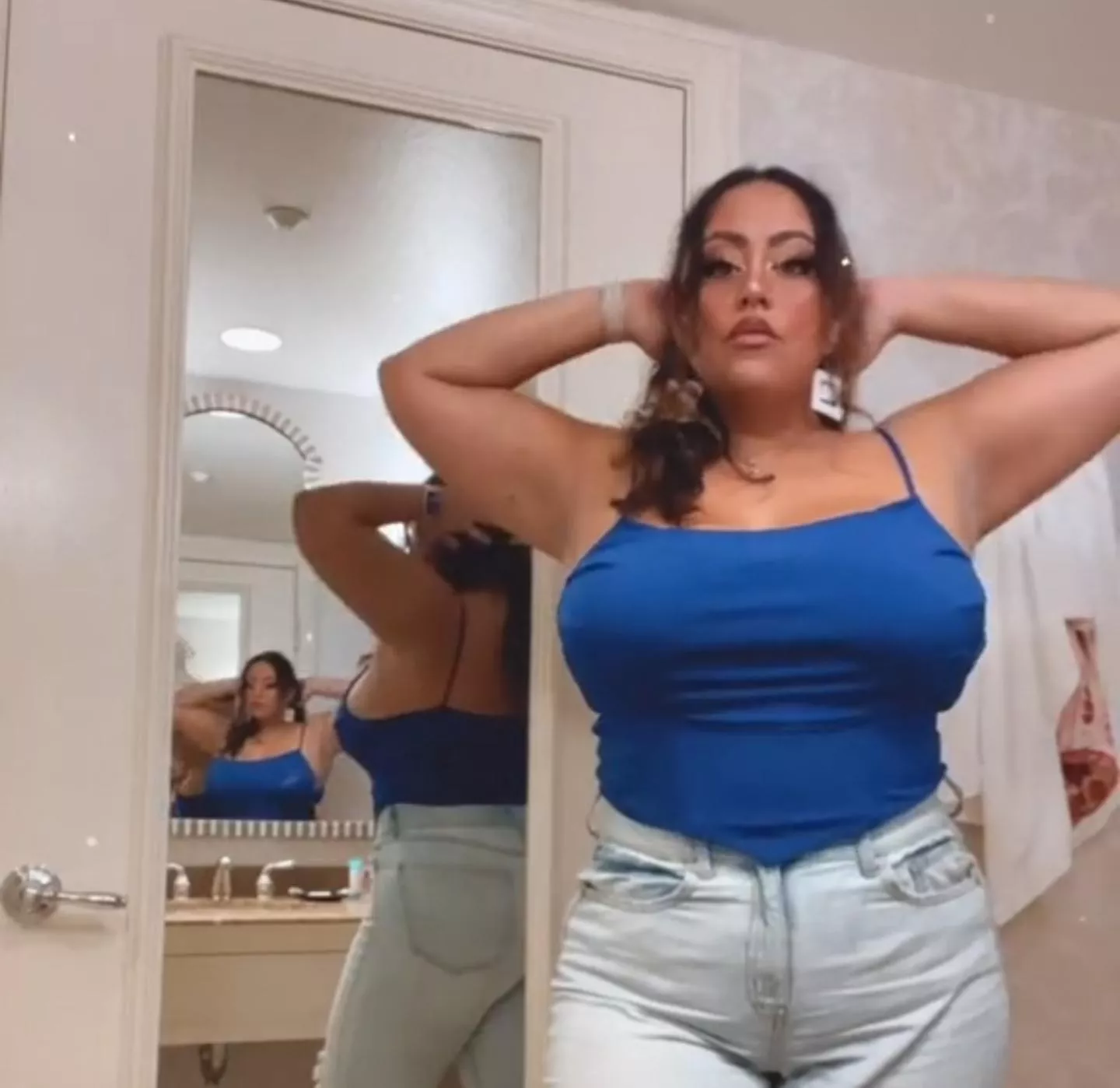 Pulling her shirt tight