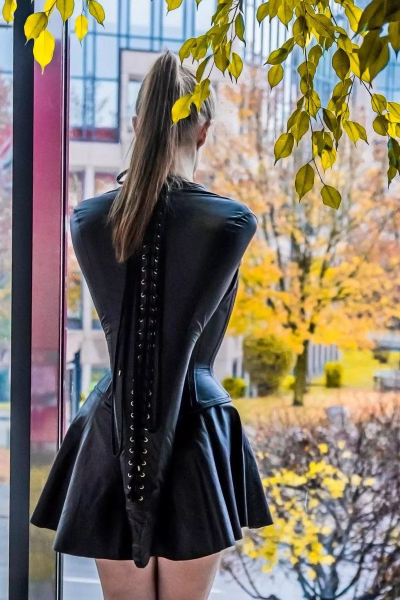 Stood in the window she stared as the tight leather corset drew her waist in and the armbinder pulled her elbows closely behind her back. She was in heaven