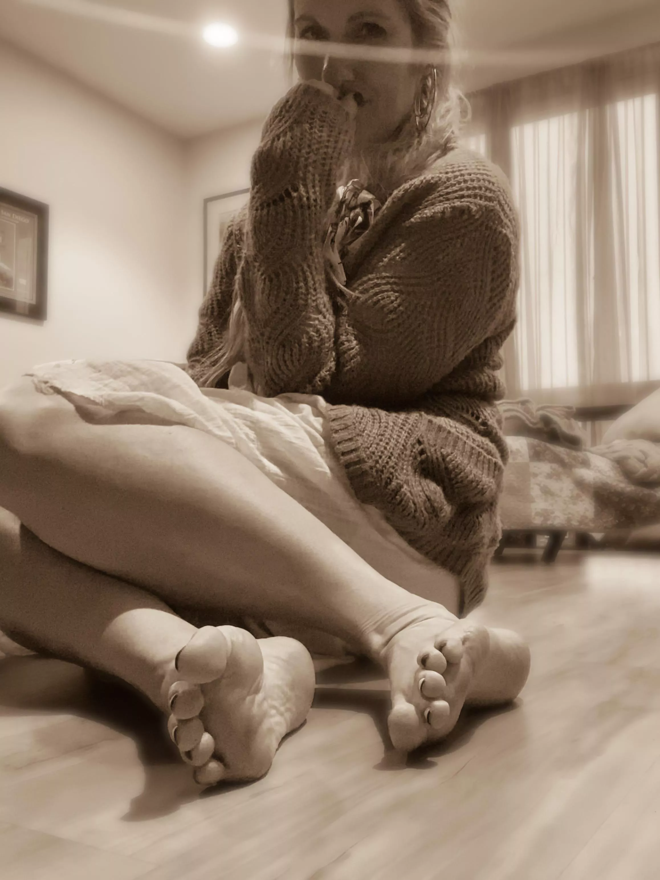 She sits on the floor, covered in dreams.