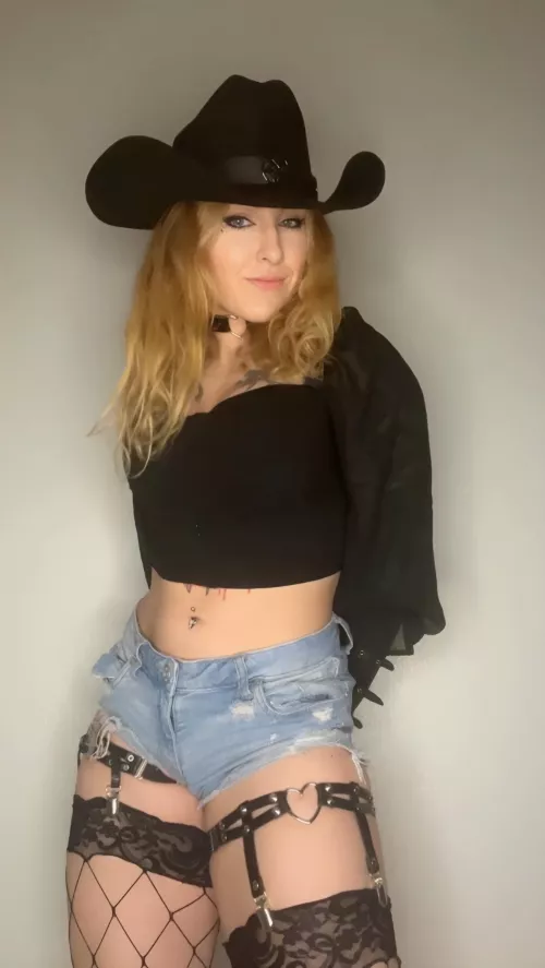 This cowboy goth girl is patiently waiting for her daddy or prince