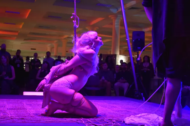 On her knees in front of a crowd