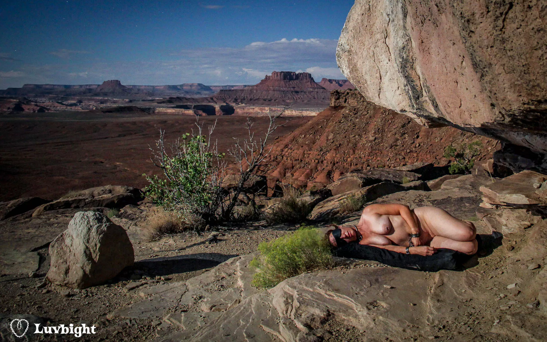 Dee Luvbight forced to sleep naked, manacled, and blindfolded on the rocks under the stars. At least she had her dog bed. 2013.