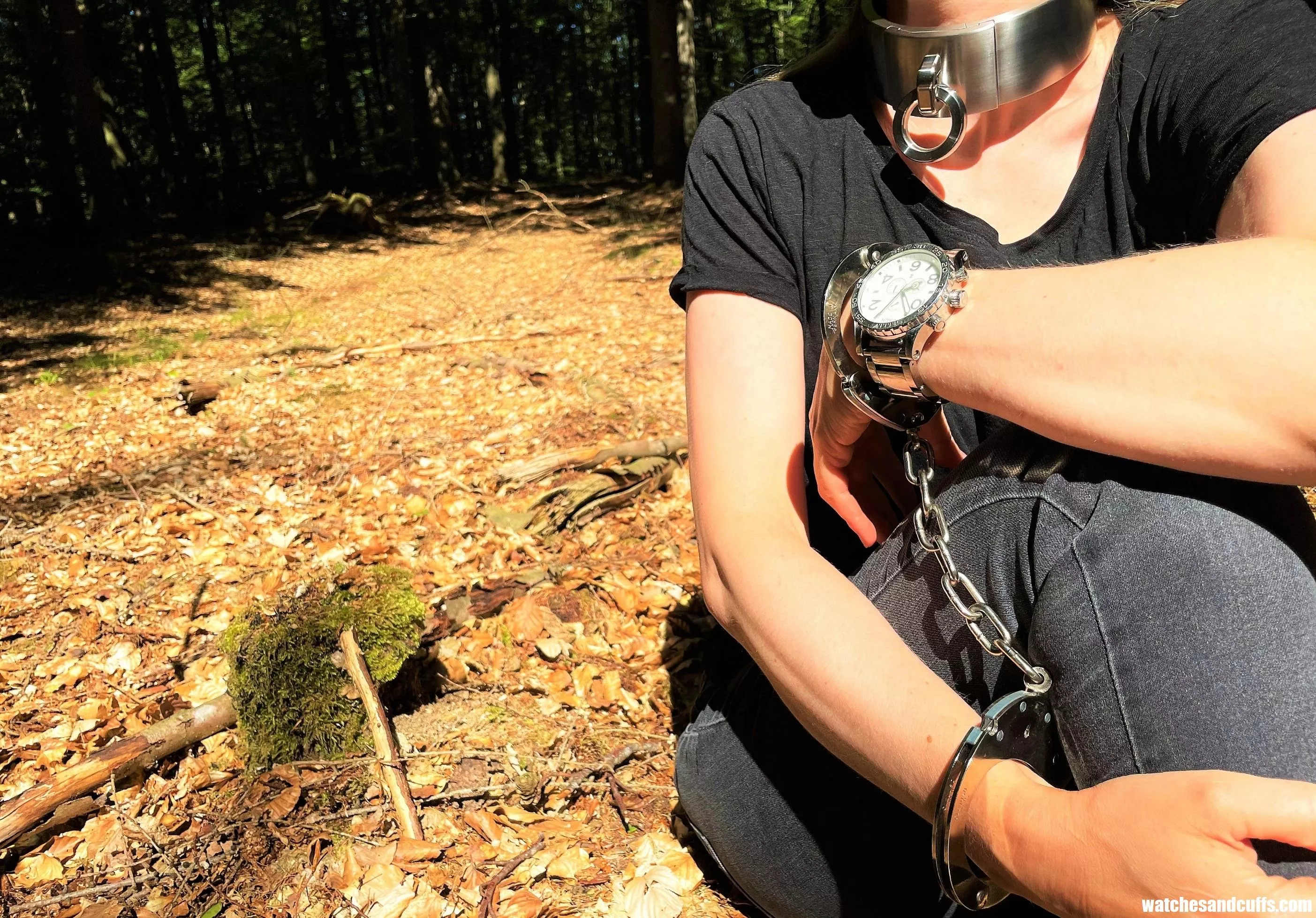 Resting after walking through the woods cuffed and collared