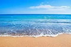 A beach is a narrow, gently sloping strip of land that lies along the edge of an ocean, lake, or river. Materials such as sand, pebbles, rocks, and seashell fragments cover beaches. Most beach materials are the products of weathering and erosion.