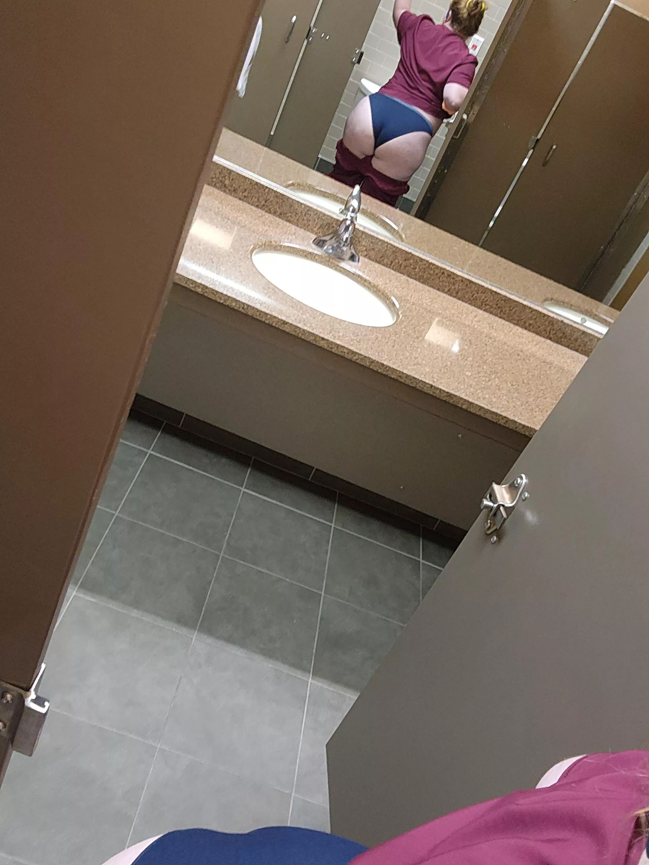 Naughty nurse in public bathroom apparently with a wedgie.