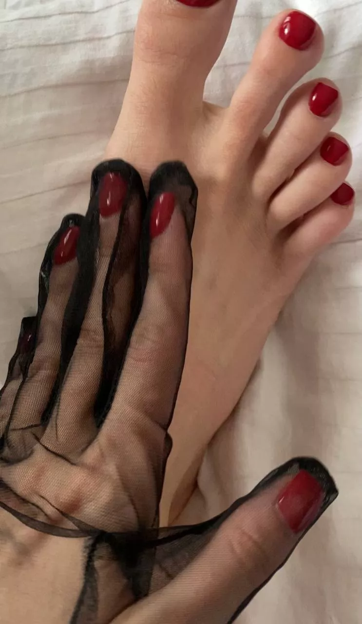 in black transparent gloves, the hands look beautiful and the red manicure looks quite mysterious