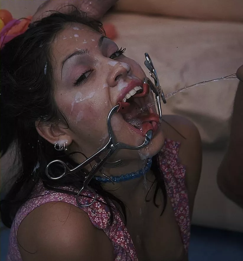 Face covered in cum with a mouth retractor in place.