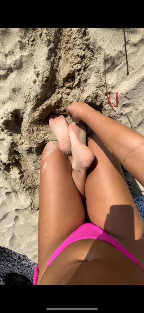 Tickling her feet with seashells on the beach