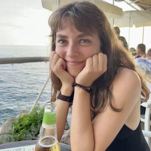 Pretty girl having a drink by the water