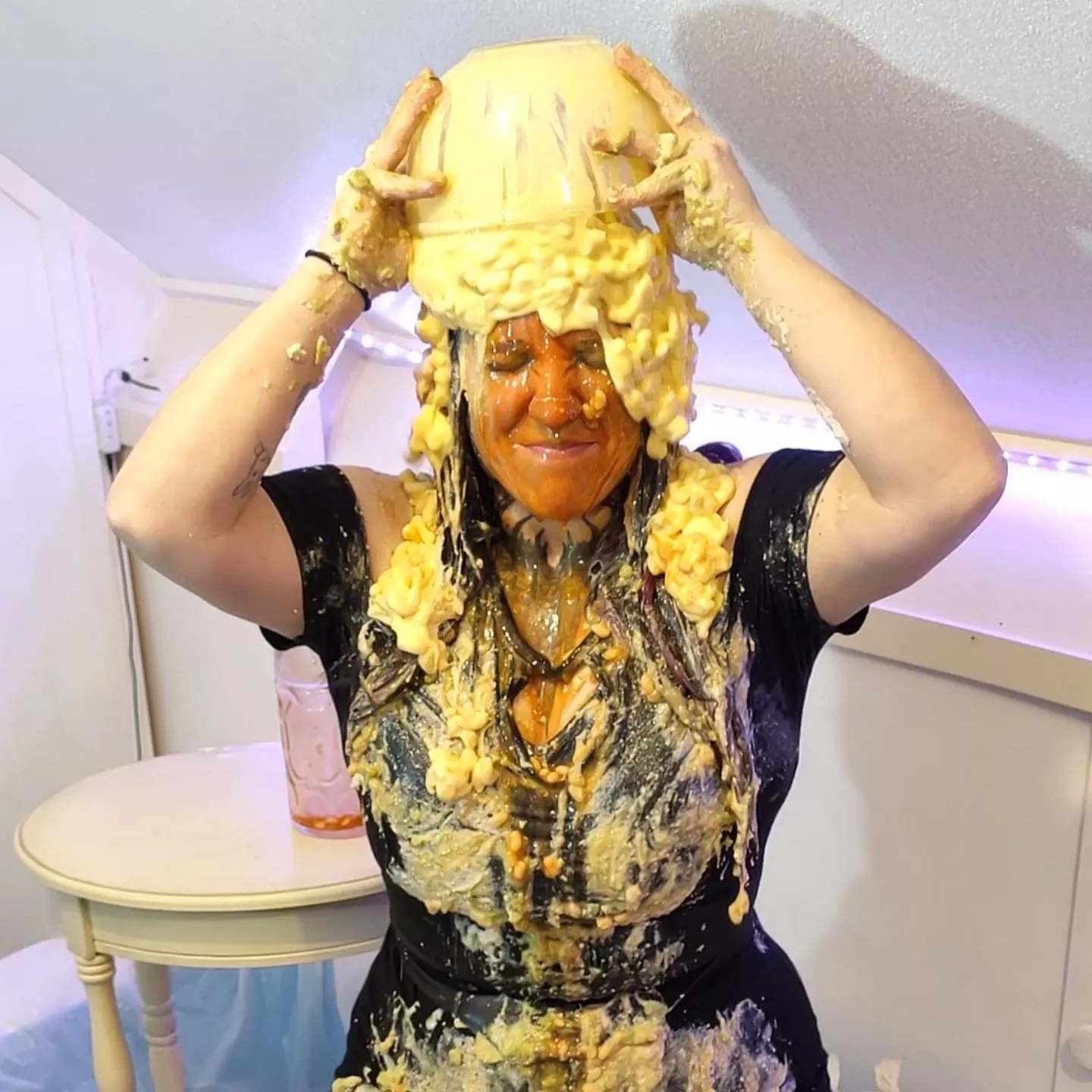 Emptying a bowl of mac and cheese on her head