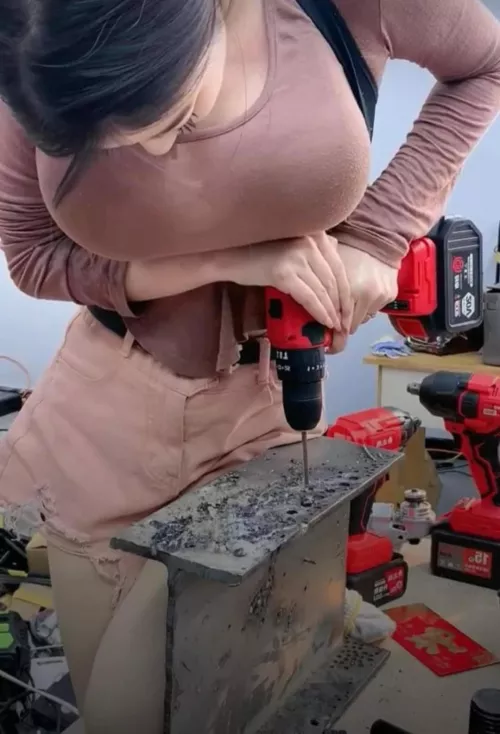 Who is this busty Asian girl using a power drill?