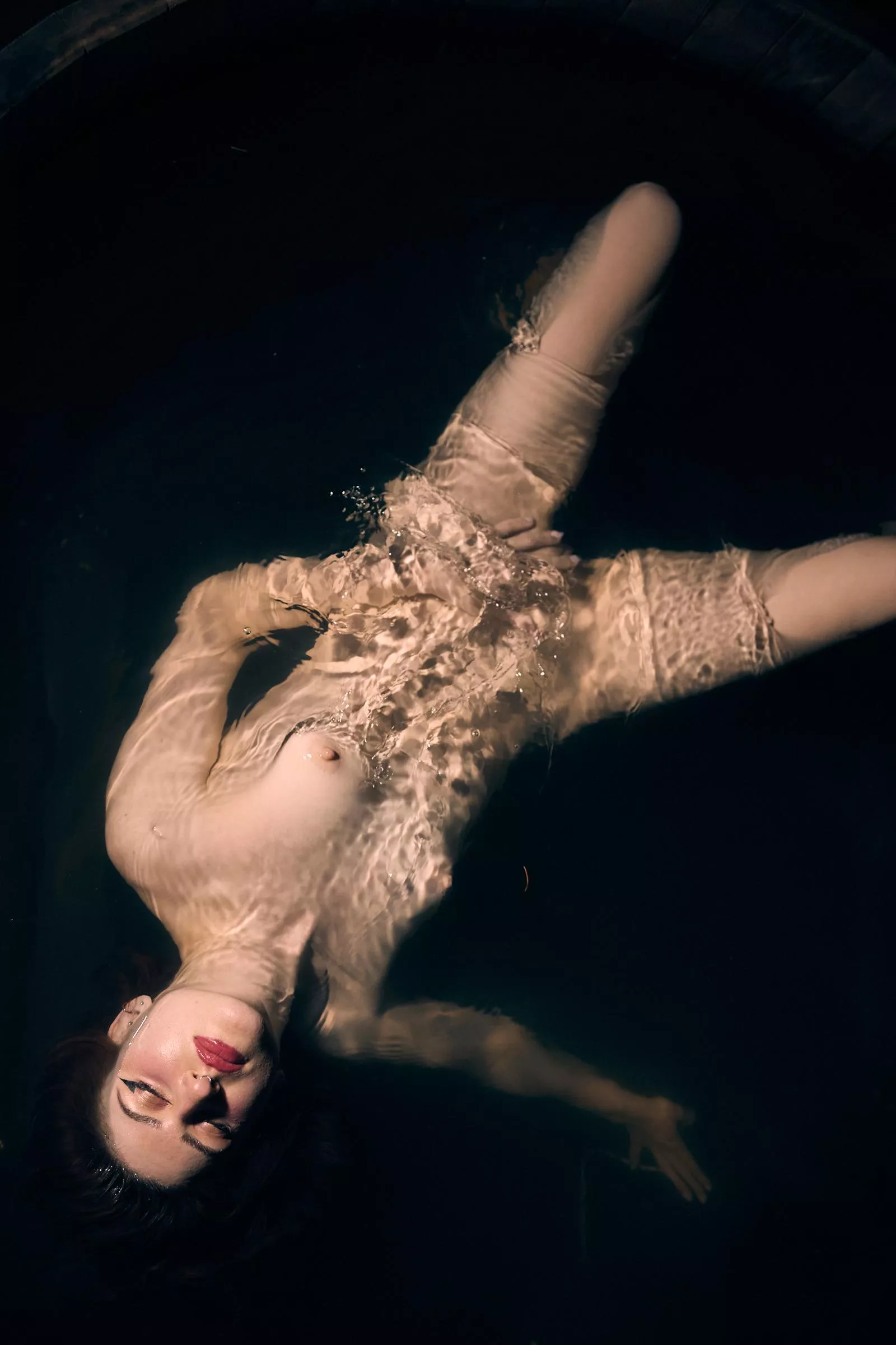 Ink melds into water's darkness.