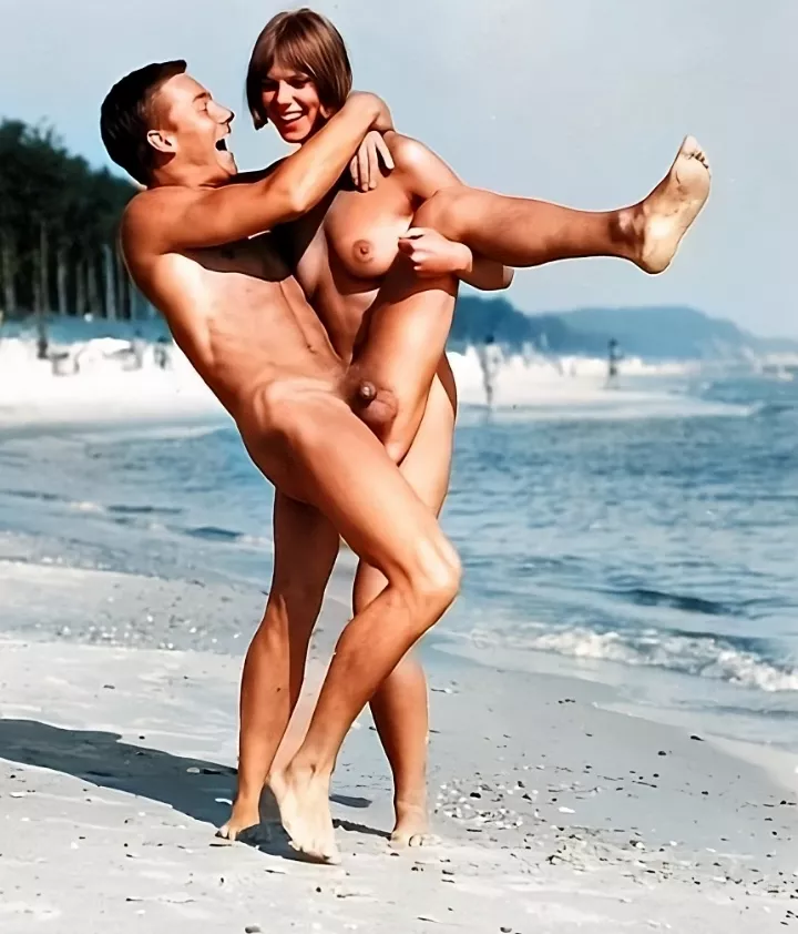Restored photo of a happy couple enjoying a freeing day on the beach in 1950's Germany.