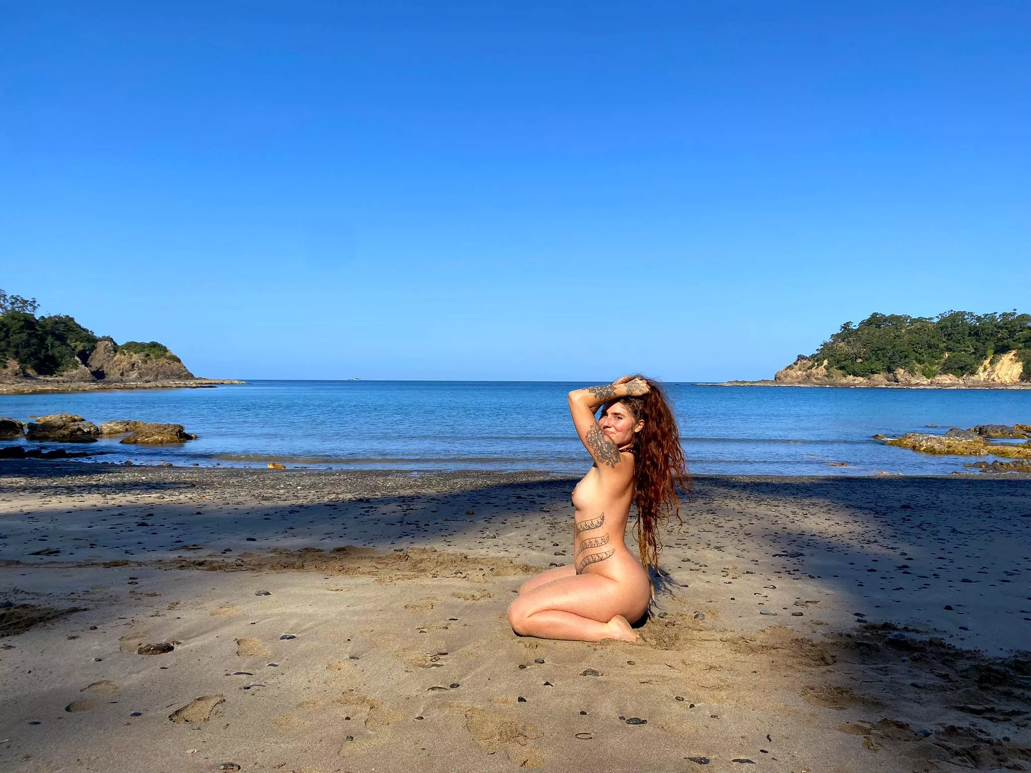 Naked and barefoot on the beach.