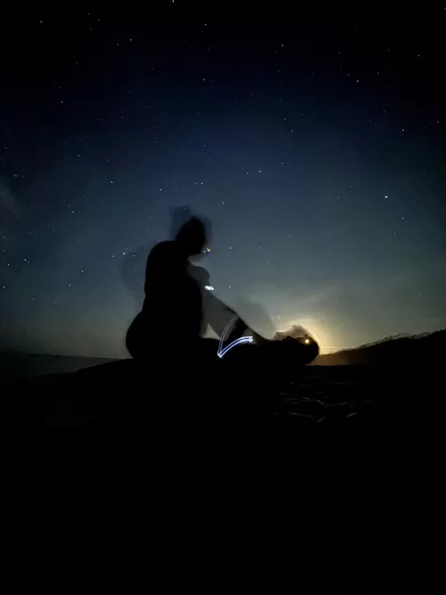 Playing on the beach at midnight, silhouetted against the moon