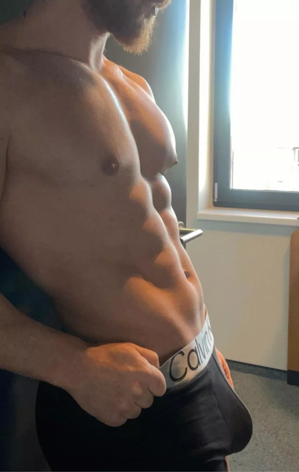 Standing in the door way waiting for you to walk by.