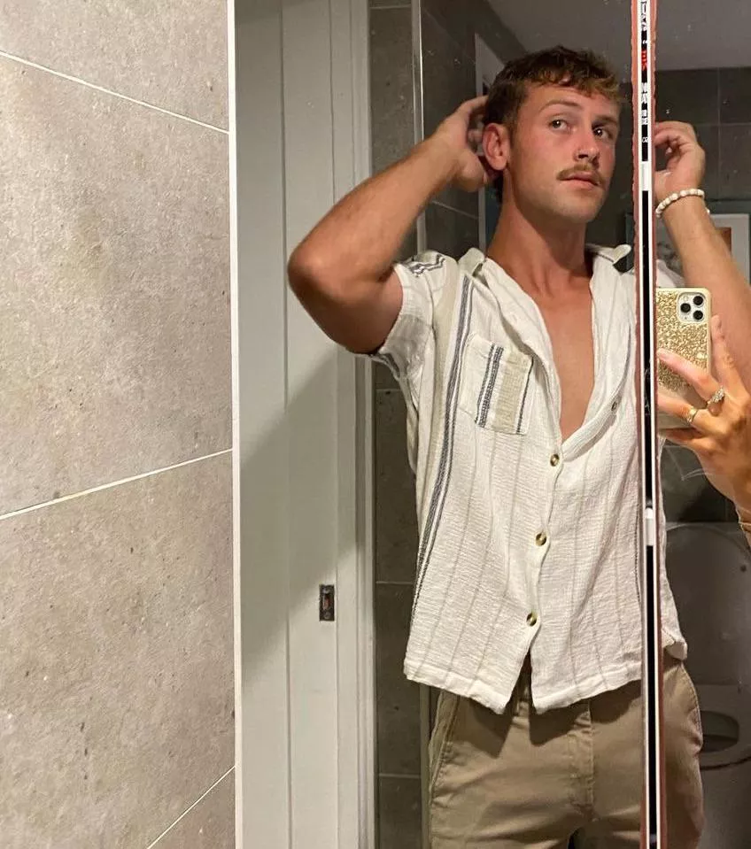 I wake up, rub my eyes, and catch a glimpse in the mirror—wait, this isn’t me. This is… wow. Tall, built, tan, and that moustache? I run my hands through my hair… whoever this guy is, he takes care of himself, and I have to admit, I look good. Li