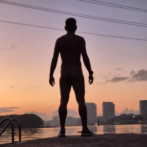 A back, a boat, a building, a beautiful sunrise. 