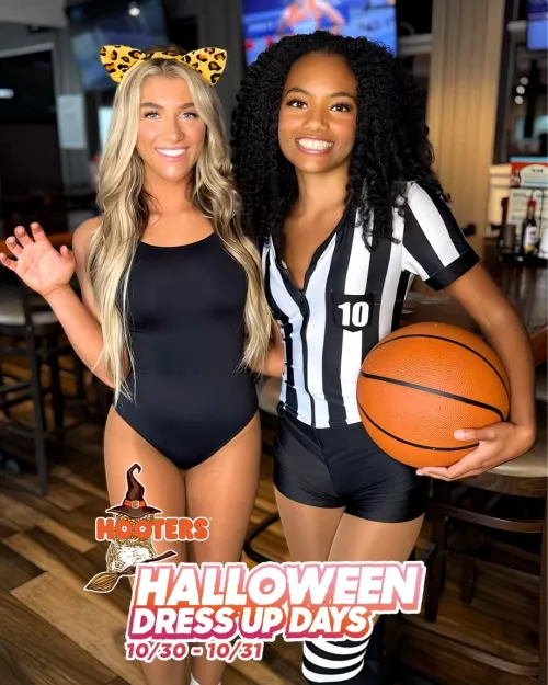 White girl in a submissive costume, black girl in a authoritative referee costume