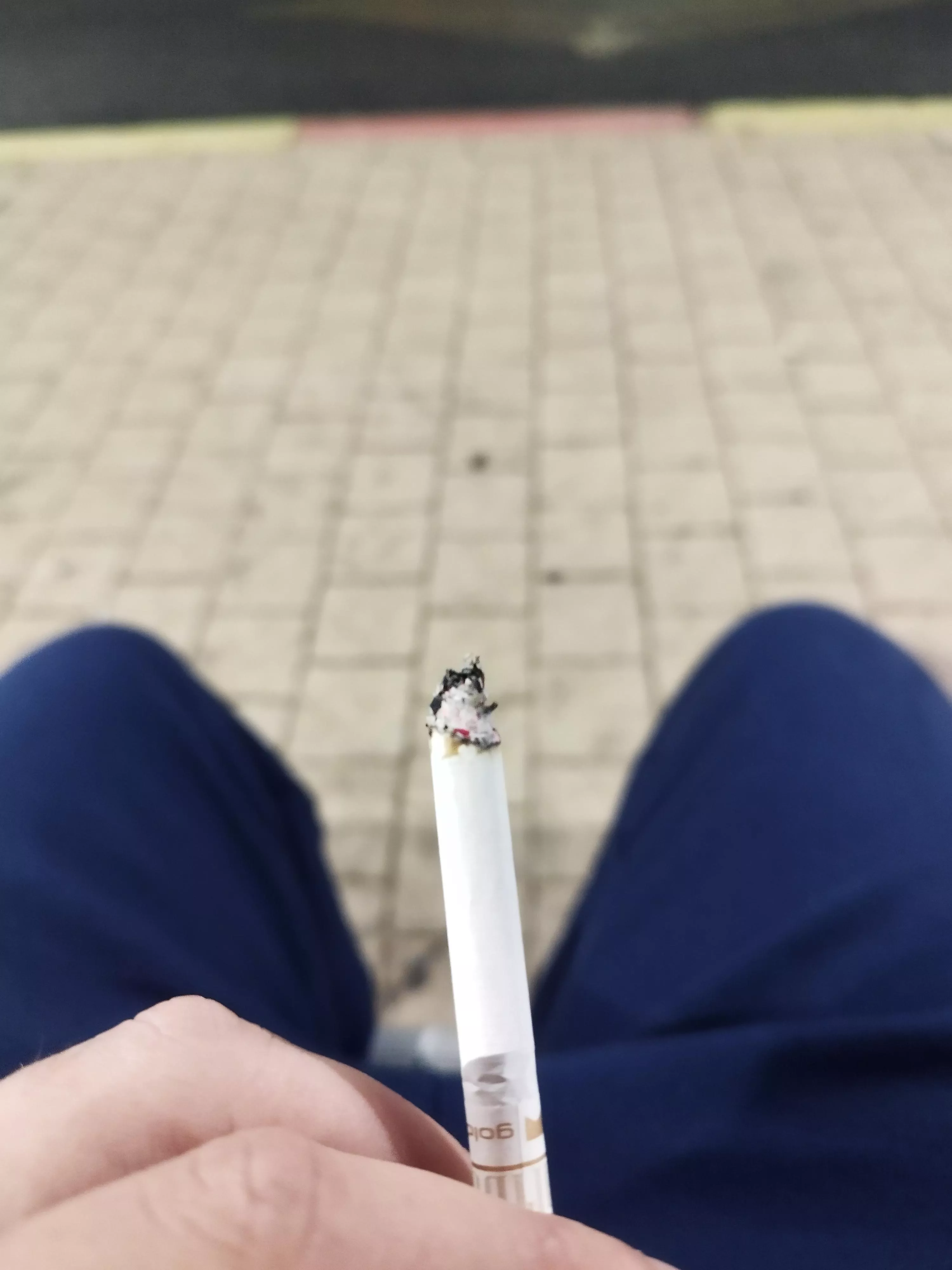 Waiting for my bus and smoking a marlboro gold that a stranger gave me 