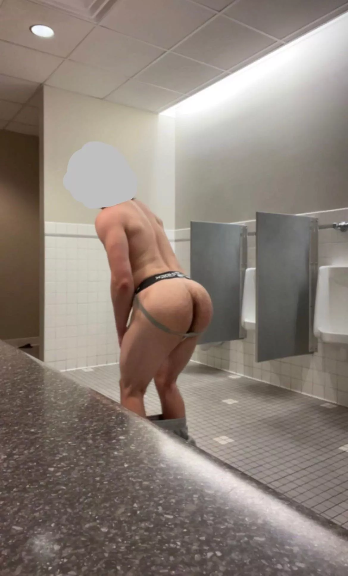 Bent over in the gym bathroom