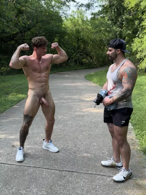 Stripping down and flexing while another guy watches 