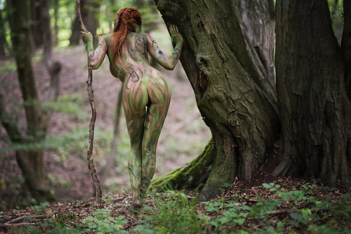Wood elf warrior who has camouflaged her body for an ambush