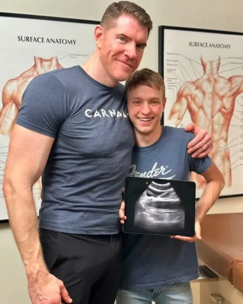 A happy couple showing their 3 mo pregnancy