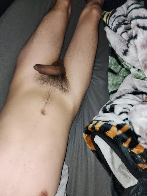 Relaxing nude in bed.