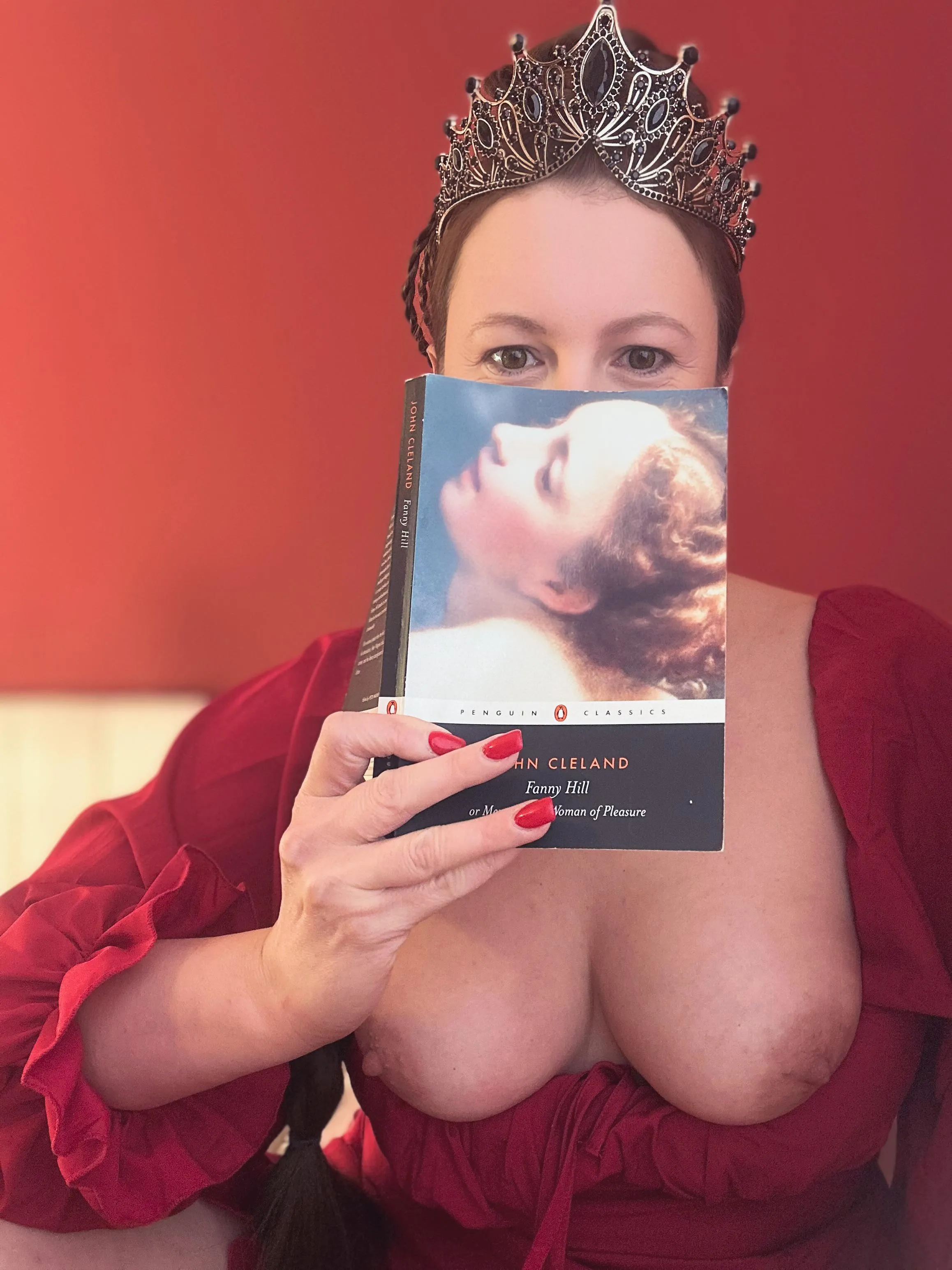 Queen of Smut—flipping through Fanny Hill with a knowing smile. A Woman of Pleasure, in literature and in life.