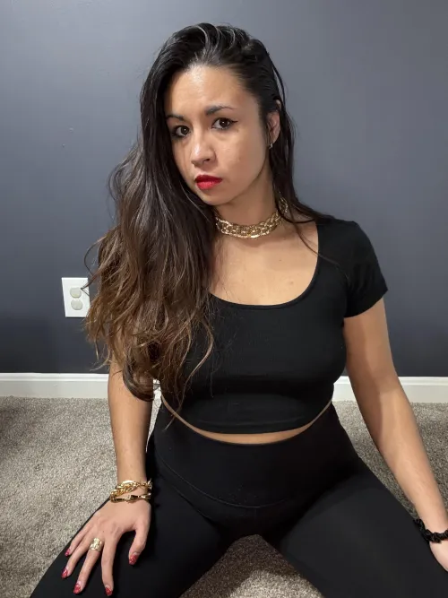 Wearing all black with red lips and nails.