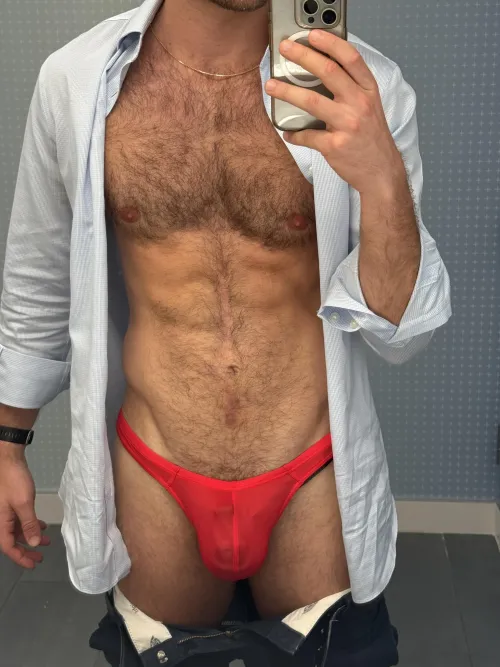 Underneath the dress clothes are a red thong and locked cock
