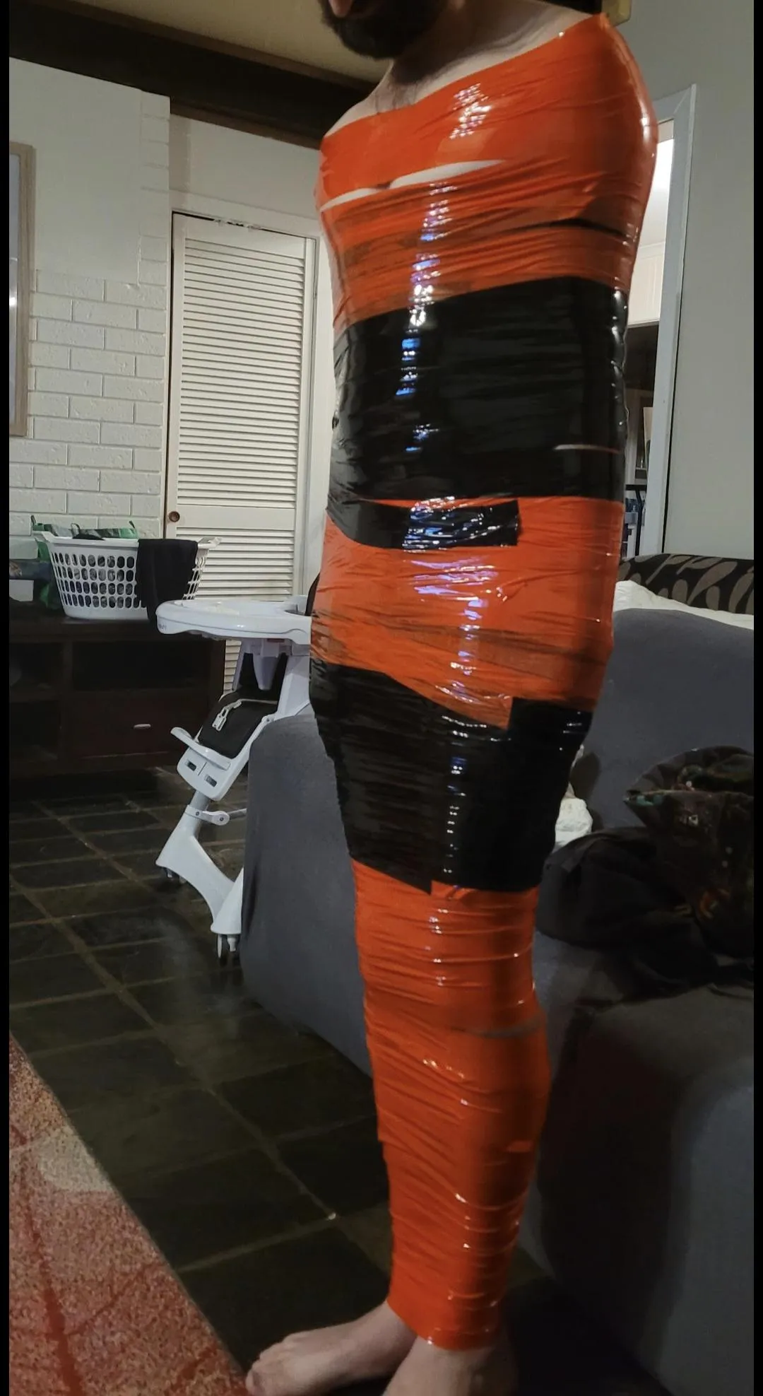 Mummified in back and red bondage tape
