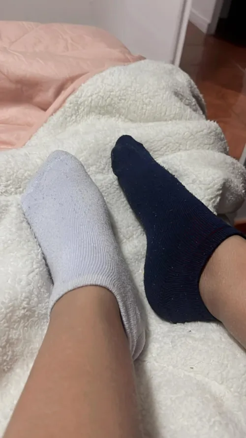 Which socked feet looks more ready to sniff or taste. White or Blue